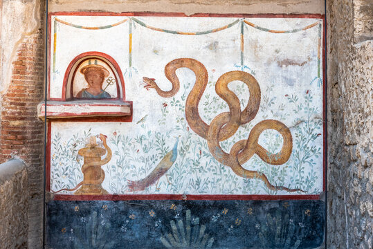 Close-up on ancient roman fresco decorating house wall in Pompeii showing a huge snake in the garden