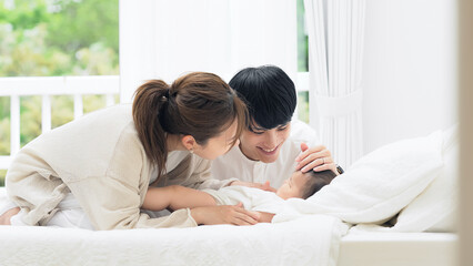 赤ちゃんを寝かしつける両親　子育てイメージ