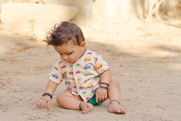 photo of Adorable Indian baby boy at outdoor and playing with sand, Pali Rajasthan , India