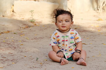 little Adorable boy sitting on a green grass Pali Rajasthan , India