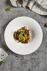 Braised beef cheeks with pearl barley and celery in creamy mushroom sauce. Veal cheek with mushroom risotto on gray stone background. Main course concept. Food menu for restaurant.