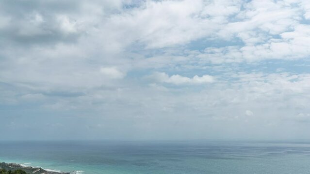 Cloudy sky and blue sea meet at the horizon by zooming out time lapse shot.