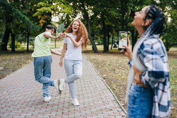 Fototapeta premium Group of teenagers internet blogger recording media content, filming video blog. Modern lifestyle concept with smart millennial guys and girls having fun