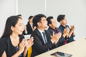 A group of young businesspeople, men, and women, were sitting intently listening