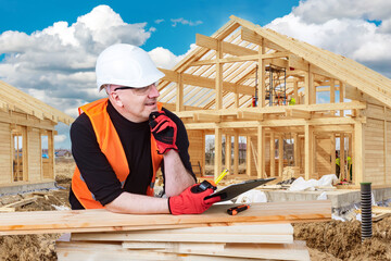 Man construction wooden buildings. Construction of houses from boards. Construction of frame buildings. Man in builders uniform holds tape measure. Guy designs country cottages. Architect in helmet