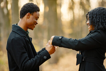 Loving black couple walking in park and enjoying autumn day