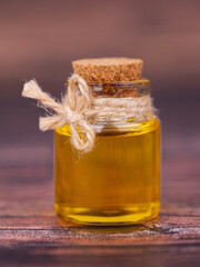Oil in a glass jar on wooden background. For cosmetic and beauty products.