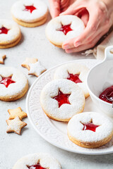 Christmas strawberry linzer cookies on gray background. Festive dessert, winter treat.