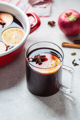 Mulled wine in glass mug, gray background. Autumn or winter cozy drink.