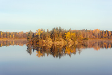 Fototapeta na wymiar rocky island on an autumn forest lake
