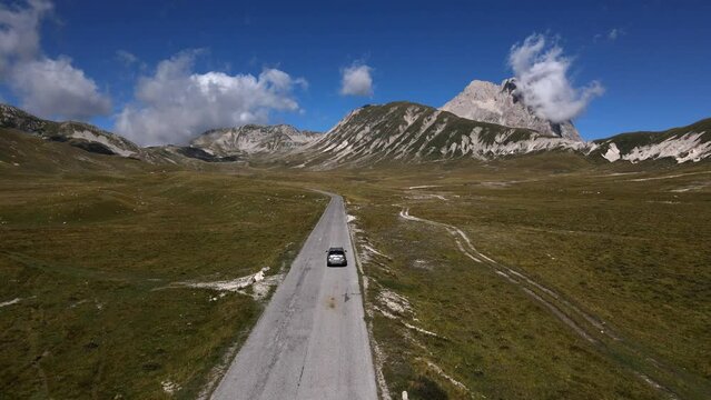 Panoramic view of the road in the mountains along which the car rides. Gran Sasso mountain, in Abruzzo region, central Italy, summer day in the mountains. Tourist destination in Italy