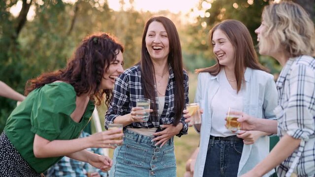 Young women dance outdoors. A group of cheerful girlfriends spend time together.