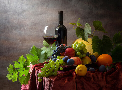 Still life with fruit and wine on a dark background