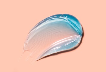 Cosmetic liquid cool blue cream smudge smear gel on beige peach background