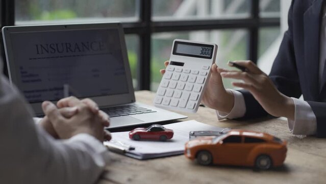 Car dealers recommend cars and interest rates and insurance at their desks with a handshake and key crouching.