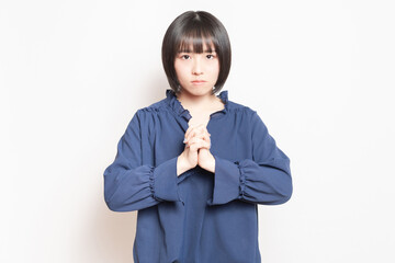 お願いのポーズをする若い女性