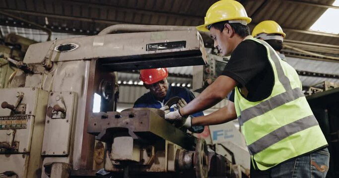 Group of machine technicians are profession inspect the electrical equipment in factory. Industrial plant engineers plan machine maintenance. African American workers work with Asian team Blue collar