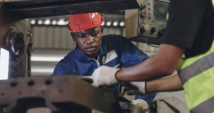 Group of machine technicians are profession inspect the electrical equipment in factory. Industrial plant engineers plan machine maintenance. African American workers work with Asian team Blue collar