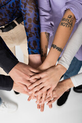 cropped view of lgbtq community people joining hands together on white background.