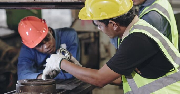 Group of machine technicians are profession inspect the electrical equipment in factory. Industrial plant engineers plan machine maintenance. African American workers work with Asian team Blue collar