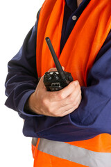 The torso of a worker in an orange reflective vest with a walkie-talkie in his hand. Selective focus, isolated on white background.