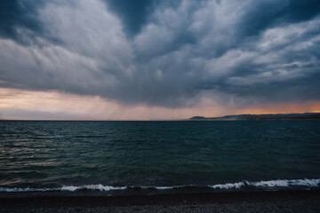 Sunset on Ugii lake in Mongolia on stormy day with big dark clouds in the sky