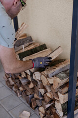 Mann beim Brennholz schlichten am Stapel