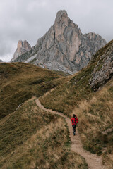 Eine Frau wandert am Passo Giau in den Dolomiten. Wechselhaftes Wetter in den Dolomiten 1