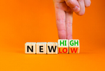 New low or high symbol. Concept words New high and New low on wooden cubes. Businessman hand....