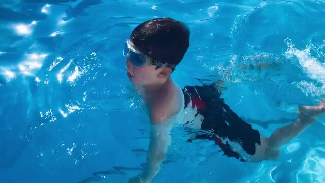 Boy swimming in the pool underwater