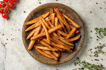Potatoes roasted on the coals on wooden board on stone table top view