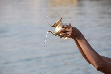 hands of hindu performing morning puja ritual at Ganges river
