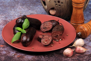 Baked blood sausage on a red plate decorated with red cranberries, Traditional Latvian blood...