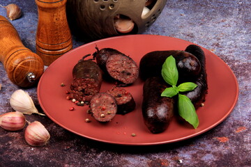 Baked blood sausage on a red plate decorated with red cranberries, Traditional Latvian blood...