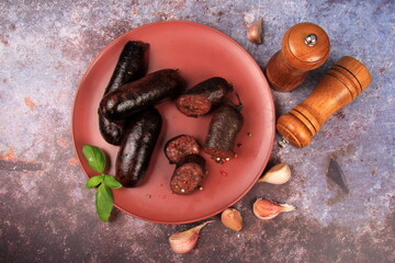 Baked blood sausage on a red plate decorated with red cranberries, Traditional Latvian blood...