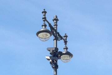 Fototapeta na wymiar Pillar with night city lighting lamps and CCTV cameras.