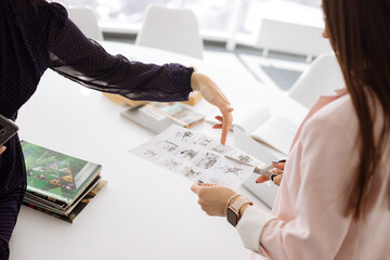 Women's hands cut out pictures for a lesson