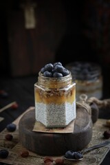 Chia pudding with nuts and blueberries on a wooden board