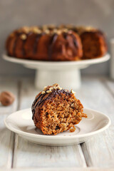 Homemade cupcake with nuts and chocolate stands on a white wooden background