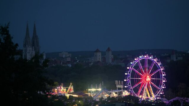Dult in Regensburg, Bavaria with city skyline in background at night with ferris wheel and all attractions