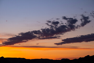 Sunset over the mountains. Red sunset in the sky with clouds.