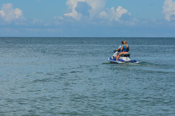 Couple on Jet Ski Ready to Enjoy the Afternoon with Clear Skies and Calm Waters on Vacation in Florida