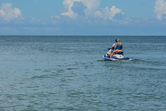 Couple on Jet Ski Ready to Enjoy the Afternoon with Clear Skies and Calm Waters on Vacation in Florida