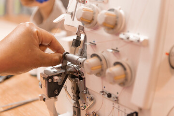 woman's hand operating a sewing machine