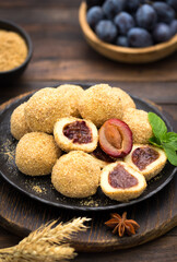 Plum dumplings with brown suggar on the wooden table