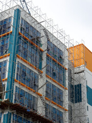 Fototapeta na wymiar JOHOR, MALAYSIA -JUNE 6, 2022: Metal scaffolding is used as a temporary structure that supports works at the construction site. Also used as a structure for working at height outside the building. 