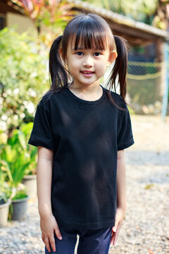 Portrait of cute girl with empty space of black t-shirt which good for kids shirt mockup.