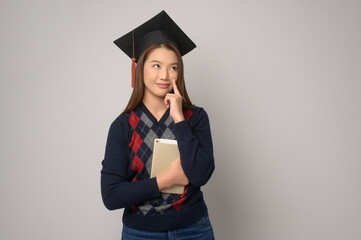 Young smiling woman holding graduation hat, education and university concept.