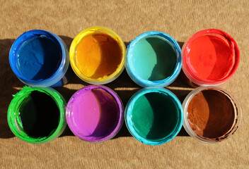 Acrylic paints in jars. Top view photo of opened pots with different colors of paint 