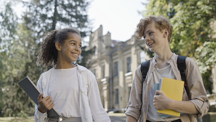 Happy multiracial school children walking together after classes, friendship